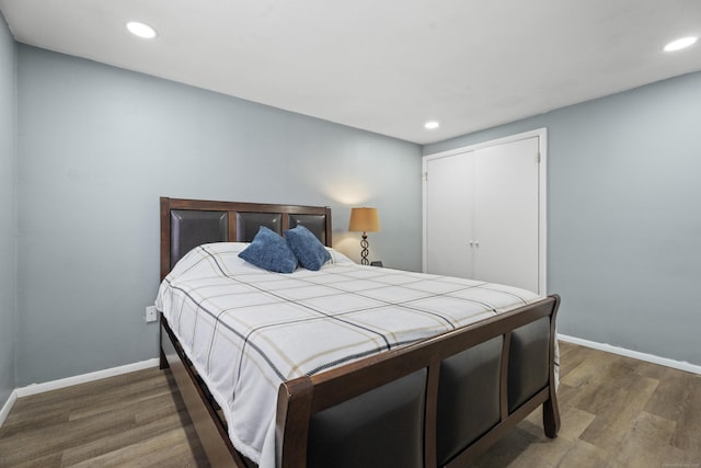 bedroom featuring baseboards, dark wood finished floors, a closet, and recessed lighting