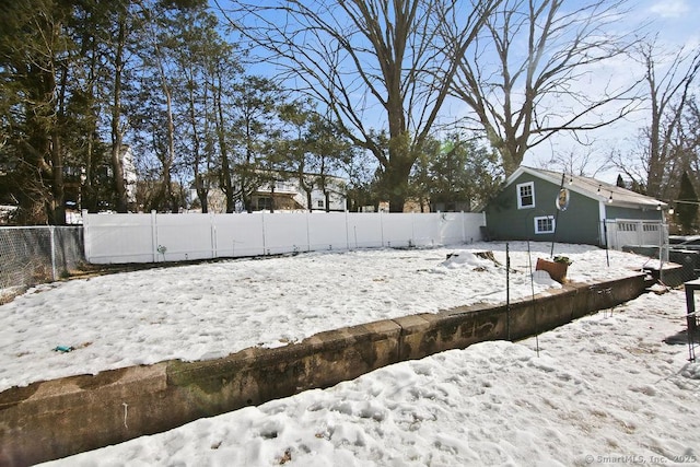 yard covered in snow with a fenced backyard