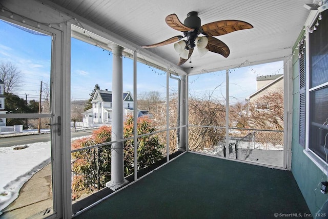 unfurnished sunroom with ceiling fan