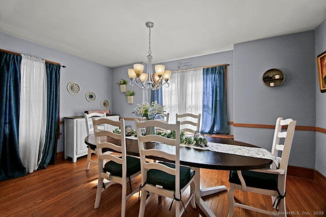 dining room with dark wood-style floors, baseboards, and a notable chandelier