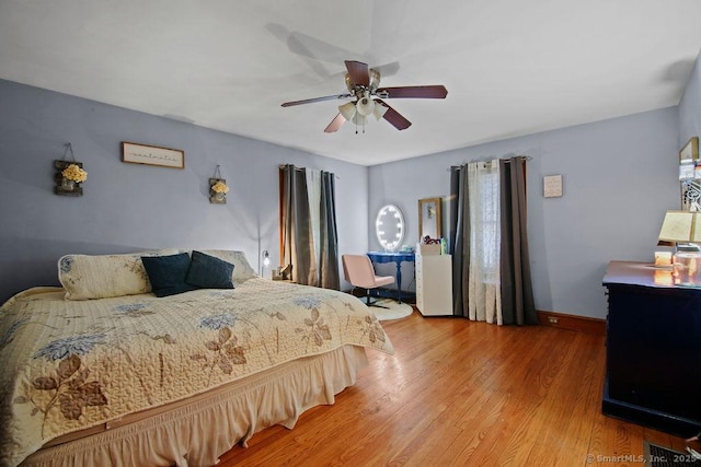 bedroom featuring visible vents, ceiling fan, baseboards, and wood finished floors