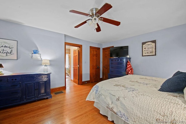 bedroom with light wood-style floors, baseboards, visible vents, and a ceiling fan