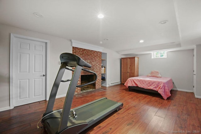 bedroom with baseboards, a baseboard heating unit, wood finished floors, and recessed lighting