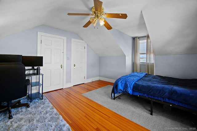 bedroom with vaulted ceiling, ceiling fan, wood finished floors, and baseboards