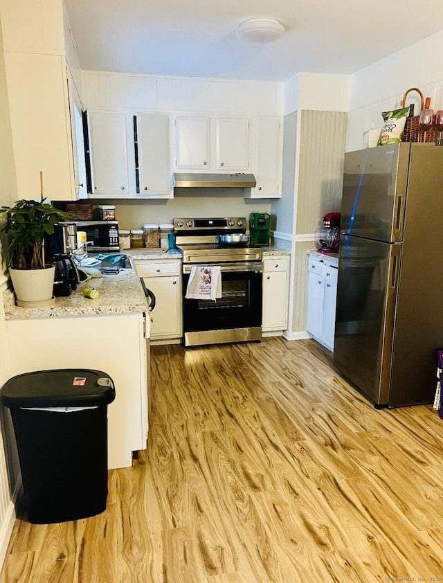 kitchen with appliances with stainless steel finishes, light wood-style flooring, white cabinets, and under cabinet range hood