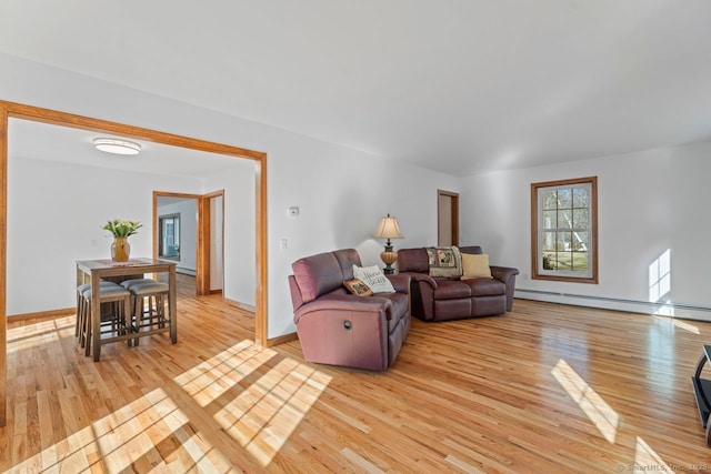 living room with baseboards, light wood finished floors, and a baseboard radiator