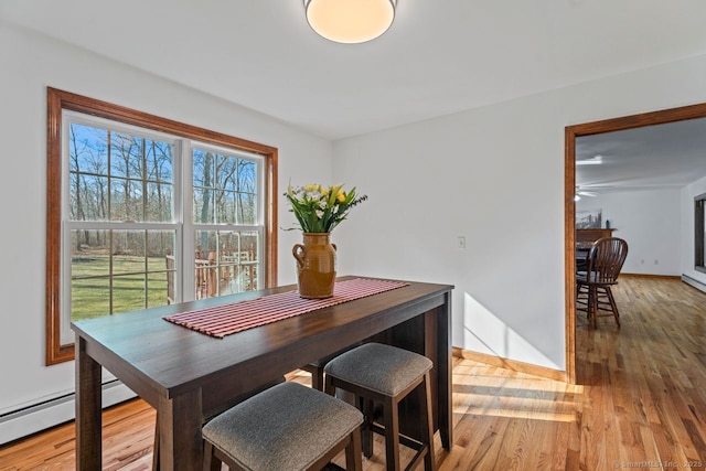 dining space with baseboards and light wood-style floors