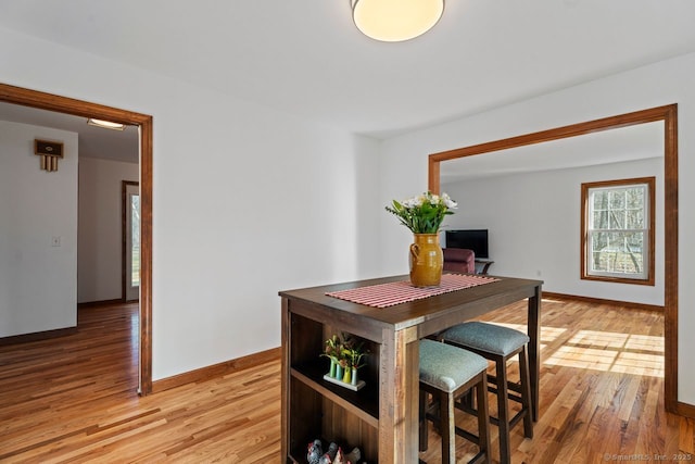 dining room featuring baseboards and light wood-style flooring