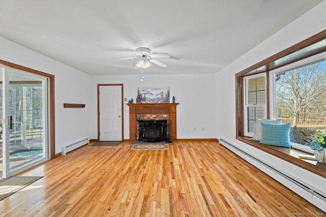 unfurnished living room featuring light wood-style floors, baseboards, baseboard heating, and ceiling fan