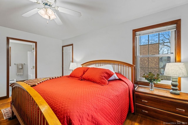 bedroom with ensuite bath, wood finished floors, and a baseboard radiator