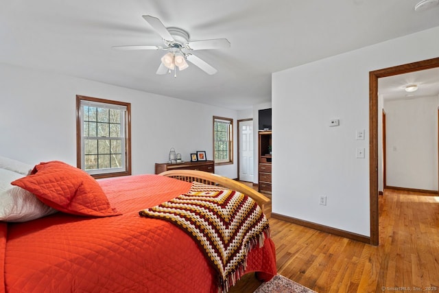 bedroom featuring a ceiling fan, baseboards, and wood finished floors