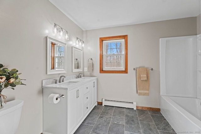 full bathroom featuring a sink, baseboard heating, double vanity, and toilet