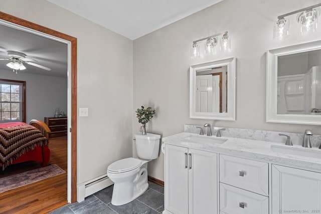 ensuite bathroom featuring a sink, a baseboard heating unit, connected bathroom, and ceiling fan