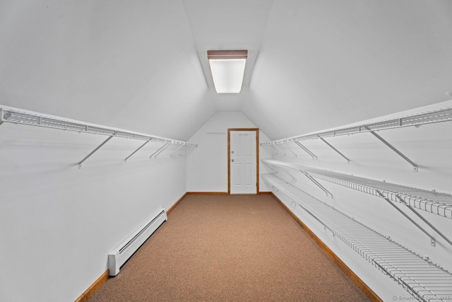 spacious closet featuring vaulted ceiling, carpet floors, and a baseboard radiator