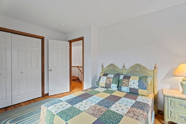 bedroom with wood finished floors and a closet