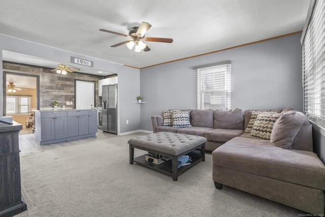 living area featuring ornamental molding, a wealth of natural light, light colored carpet, and visible vents