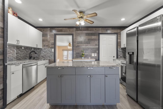 kitchen with stainless steel appliances, gray cabinets, white cabinets, and light stone counters