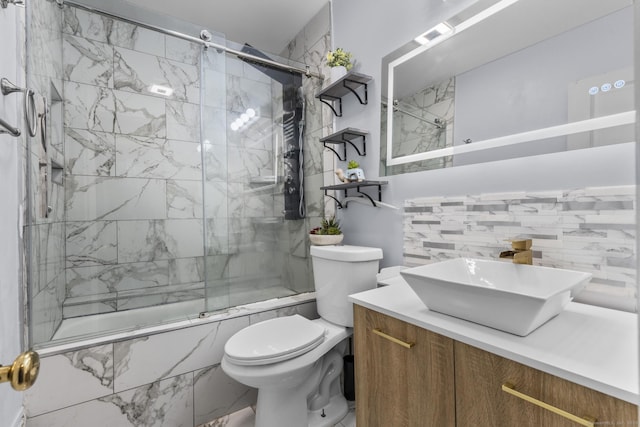 bathroom featuring backsplash, toilet, tiled shower / bath, and vanity