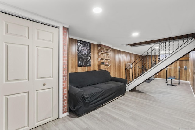 sitting room featuring stairs, recessed lighting, light wood-style flooring, and wooden walls