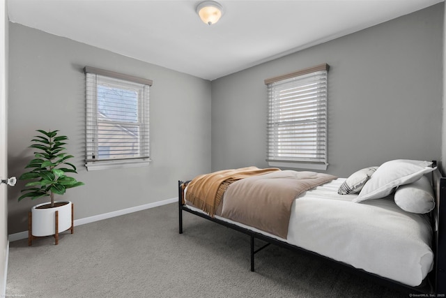 bedroom featuring carpet, multiple windows, and baseboards