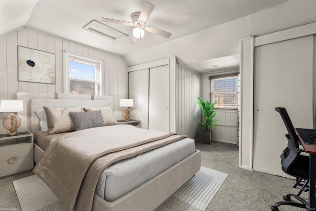 bedroom featuring vaulted ceiling, multiple windows, and light colored carpet