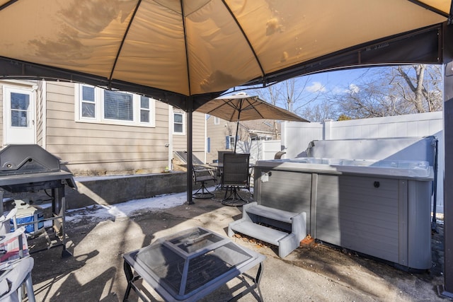 view of patio / terrace featuring outdoor dining area, a hot tub, a gazebo, a grill, and fence