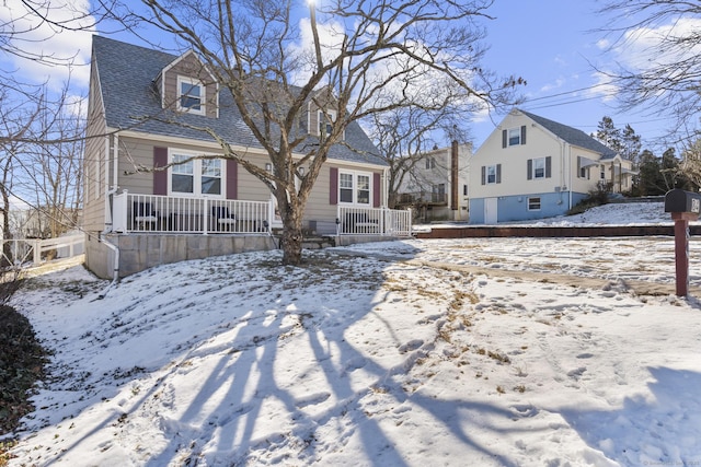 exterior space with a porch and a shingled roof