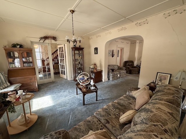 living room featuring arched walkways and dark colored carpet