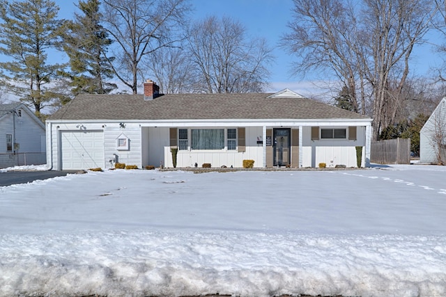 ranch-style home with a garage, a chimney, and board and batten siding