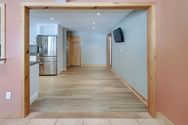 hall with baseboards, light wood-type flooring, and recessed lighting