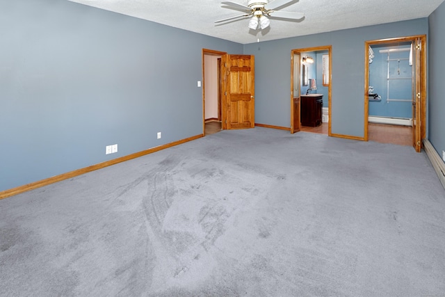 unfurnished bedroom with a baseboard heating unit, carpet, baseboards, and ensuite bathroom