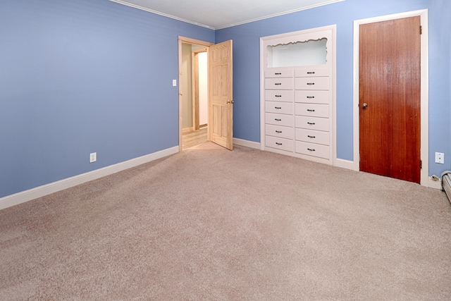 unfurnished bedroom featuring carpet, ornamental molding, and baseboards