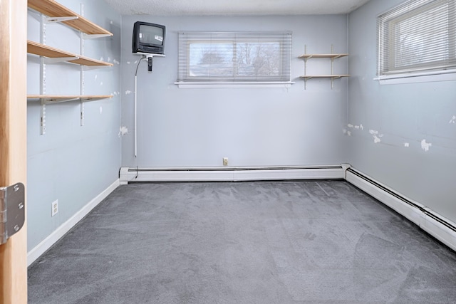 empty room with dark colored carpet, a baseboard radiator, and baseboards