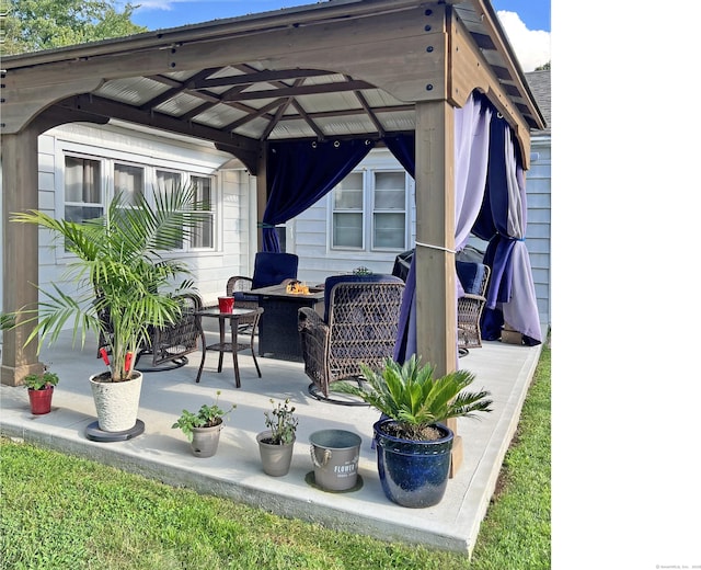 view of patio / terrace with an outdoor fire pit and a gazebo