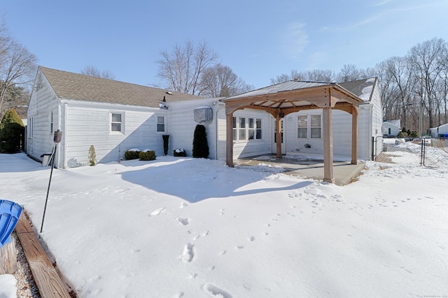 snow covered rear of property with fence