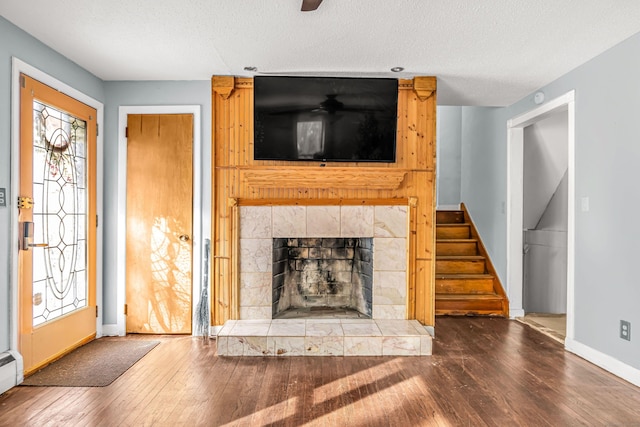 unfurnished living room featuring a wealth of natural light, stairway, and wood finished floors