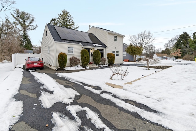 view of front of house featuring aphalt driveway and solar panels