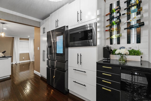 kitchen with dark wood-style flooring, stainless steel appliances, dark countertops, white cabinets, and beverage cooler