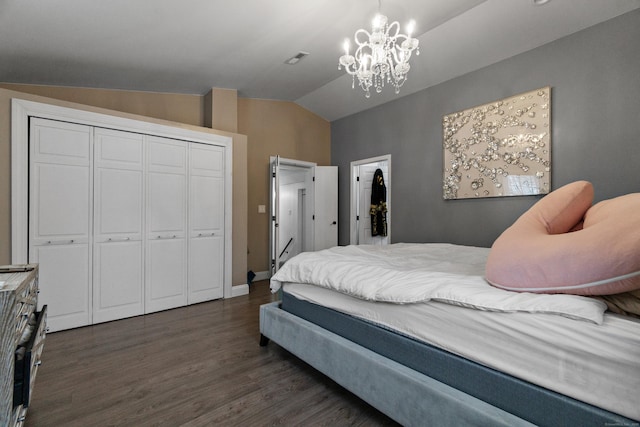 bedroom featuring visible vents, lofted ceiling, dark wood-style floors, a chandelier, and a closet