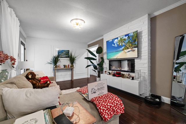 living room featuring a large fireplace, ornamental molding, dark wood-type flooring, and baseboards