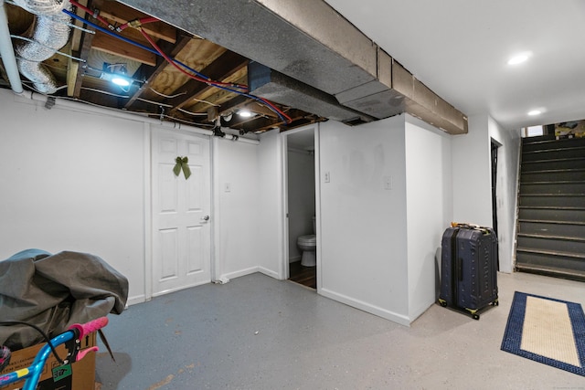 finished basement featuring stairway and baseboards