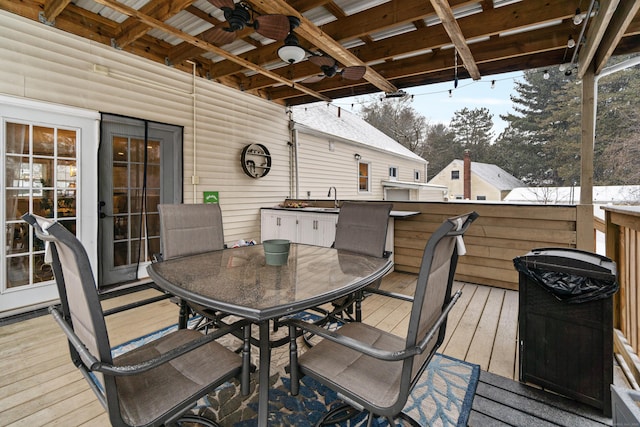 wooden deck with a ceiling fan, outdoor dining area, and a sink