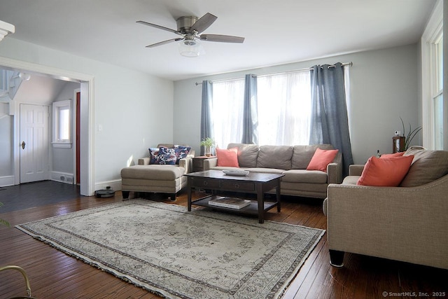 living area with dark wood-style flooring, a ceiling fan, and baseboards