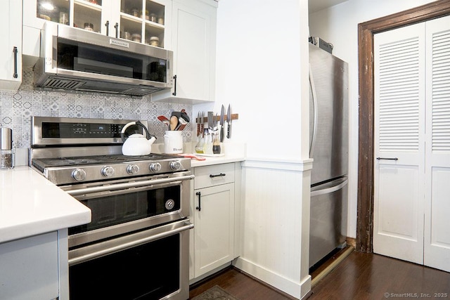 kitchen with dark wood-style floors, appliances with stainless steel finishes, and white cabinetry