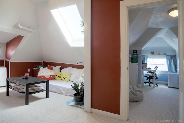 carpeted bedroom with vaulted ceiling with skylight