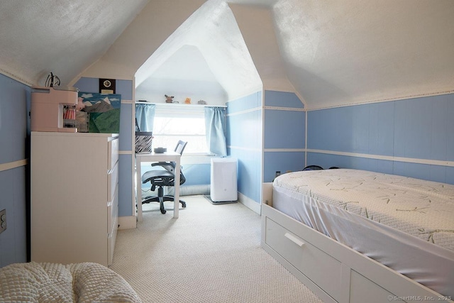 carpeted bedroom featuring lofted ceiling and a textured ceiling