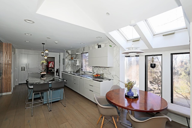 kitchen featuring tasteful backsplash, modern cabinets, hardwood / wood-style flooring, and decorative light fixtures