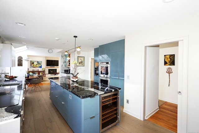 kitchen with blue cabinets, beverage cooler, hardwood / wood-style flooring, and modern cabinets