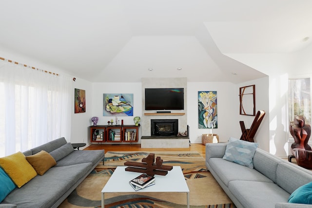 living area with lofted ceiling, wood finished floors, and a high end fireplace