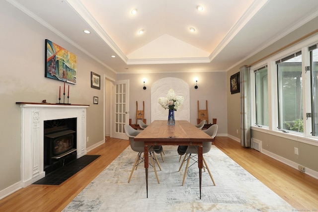 dining room featuring baseboards, a tray ceiling, crown molding, light wood-type flooring, and recessed lighting